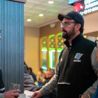 Group of three event attendees standing in conversation